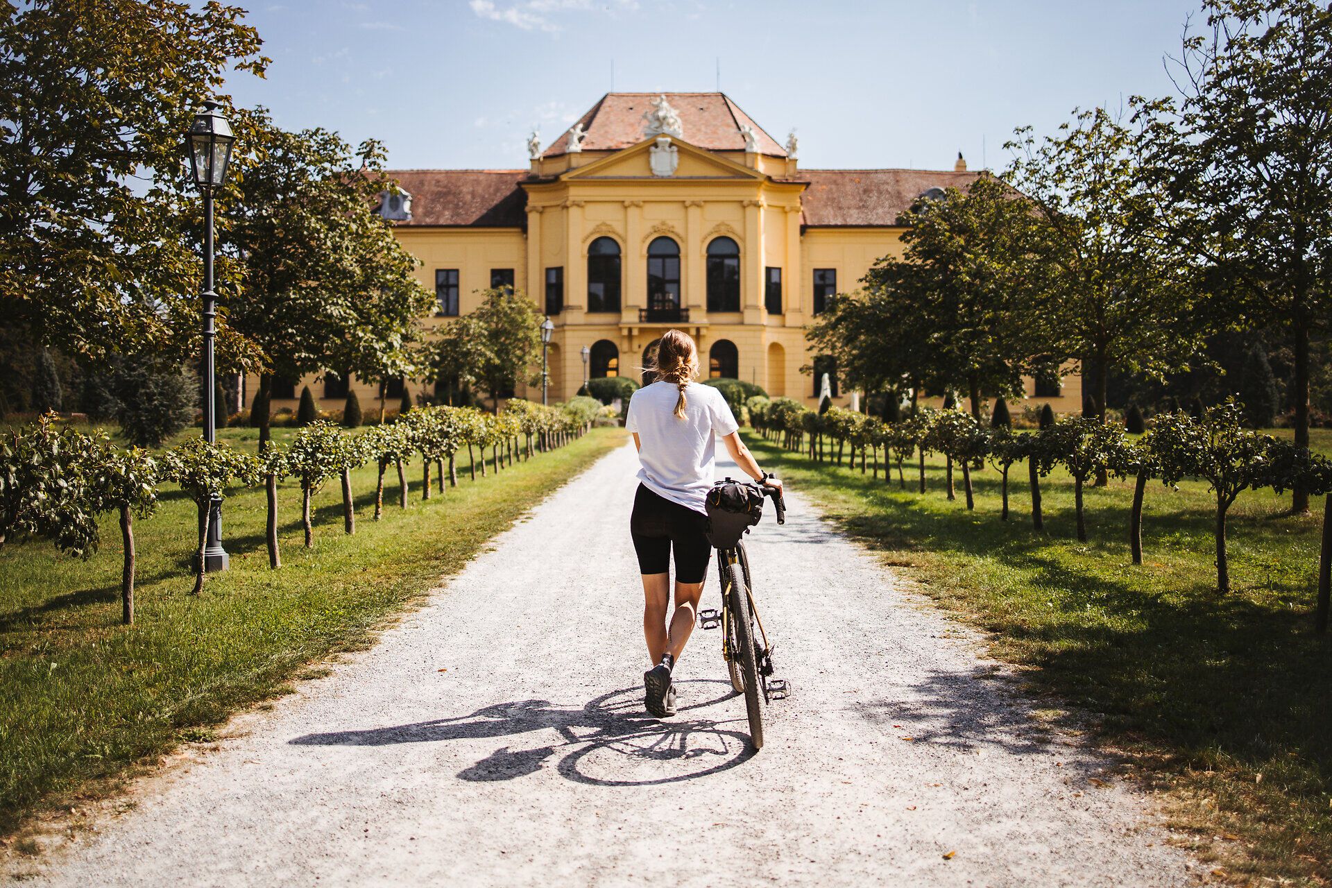 Slnečný deň vás pozýva na relaxačnú cyklistickú túru, zatiaľ čo v pozadí žiari majestátna kulisa zámku Eckartsau. Zvlnené kopce a svieže vinice pozdĺž cesty vytvárajú malebnú atmosféru, ktorá vás pozýva na dlhšie zotrvanie.
