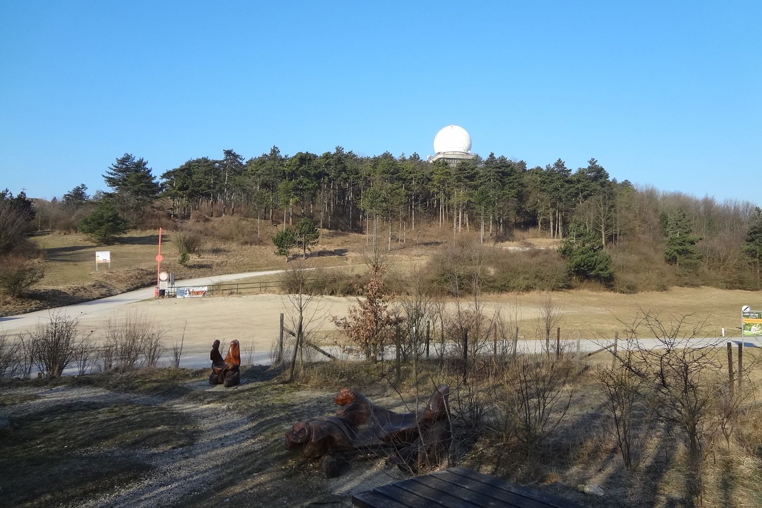 Krajina s kopcami, lesom a radarovou kupolou na vrchu Buschberg.