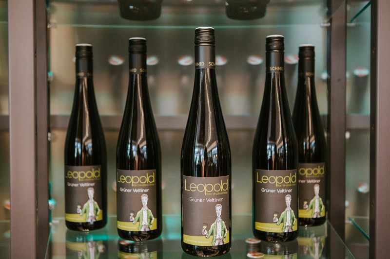 Päť fliaš vína veltlínske zelené značky Leopold na polici.
