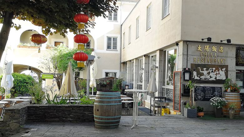 Čínska reštaurácia s červenými lampášmi a vonkajším priestorom.