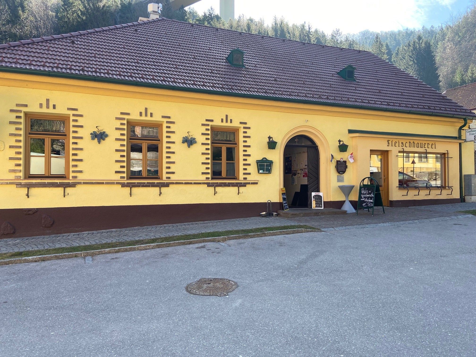 Žltá budova s nápisom "Fleischhauerei" a vchodom.