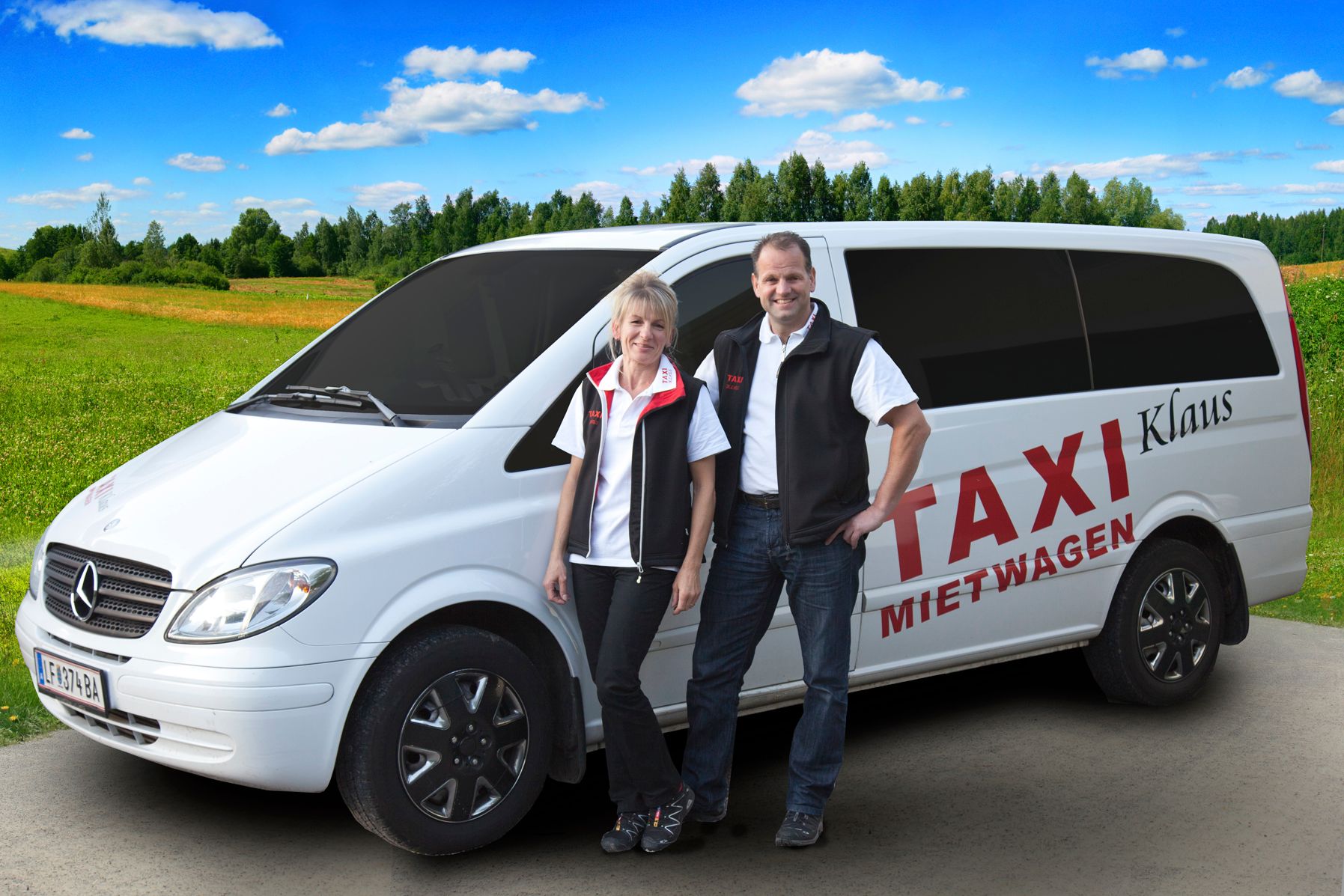 Dvaja ľudia stoja pred bielou dodávkou Mercedes s nápisom "Taxi Mietwagen Klaus" na vidieckej ceste.