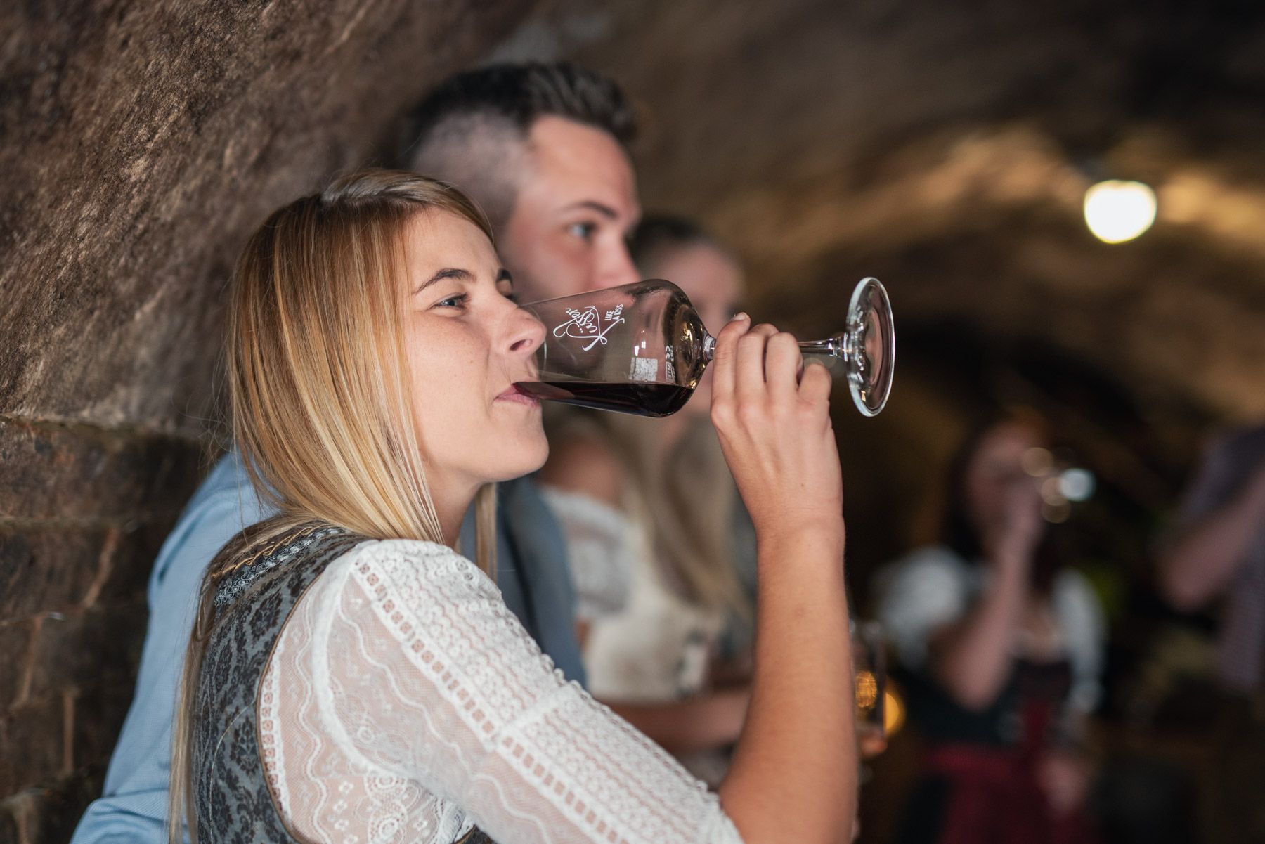 Žena pije víno vo vínnej pivnici.