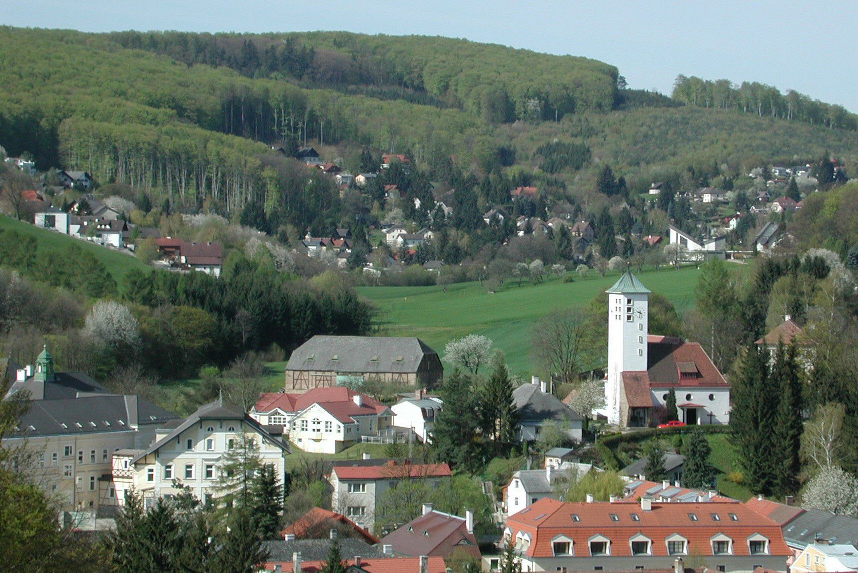 Panoráma Gablitzu s kostolom a okolitými domami pred zalesnenými kopcami.