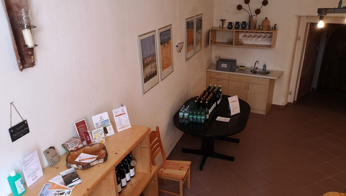 Pohľad do interiéru rustikálnej pivnice so samoobslužným pultom a nápojmi.