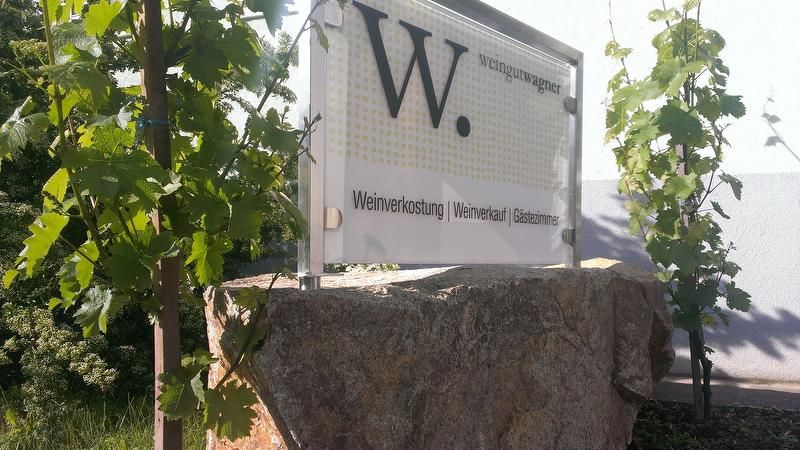 Znak vinárstva Wagner s viničom v pozadí.