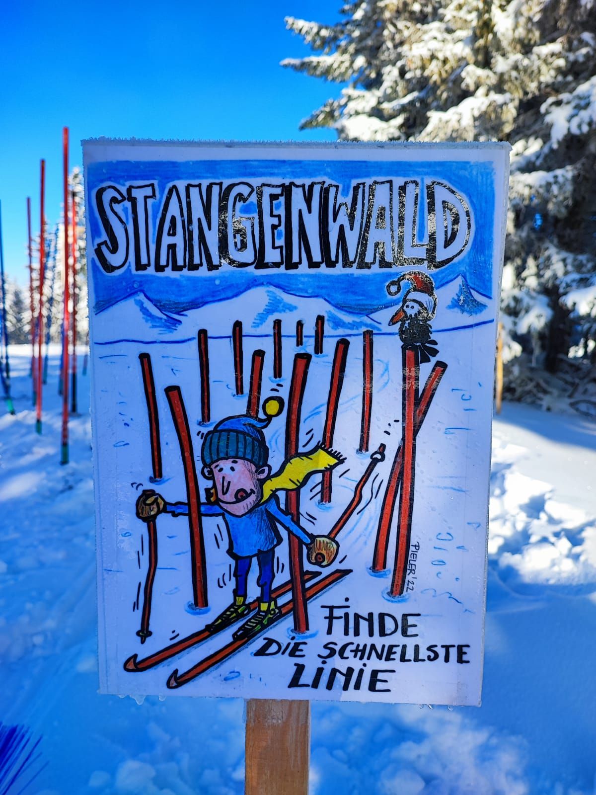Nápis v snehu s kreslenou postavičkou na lyžiach a textom "Stangenwald, nájdi najrýchlejšiu trať".