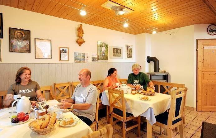 Raňajky sa podávajú v útulnej miestnosti s dreveným nábytkom a dekoráciami na stenách.