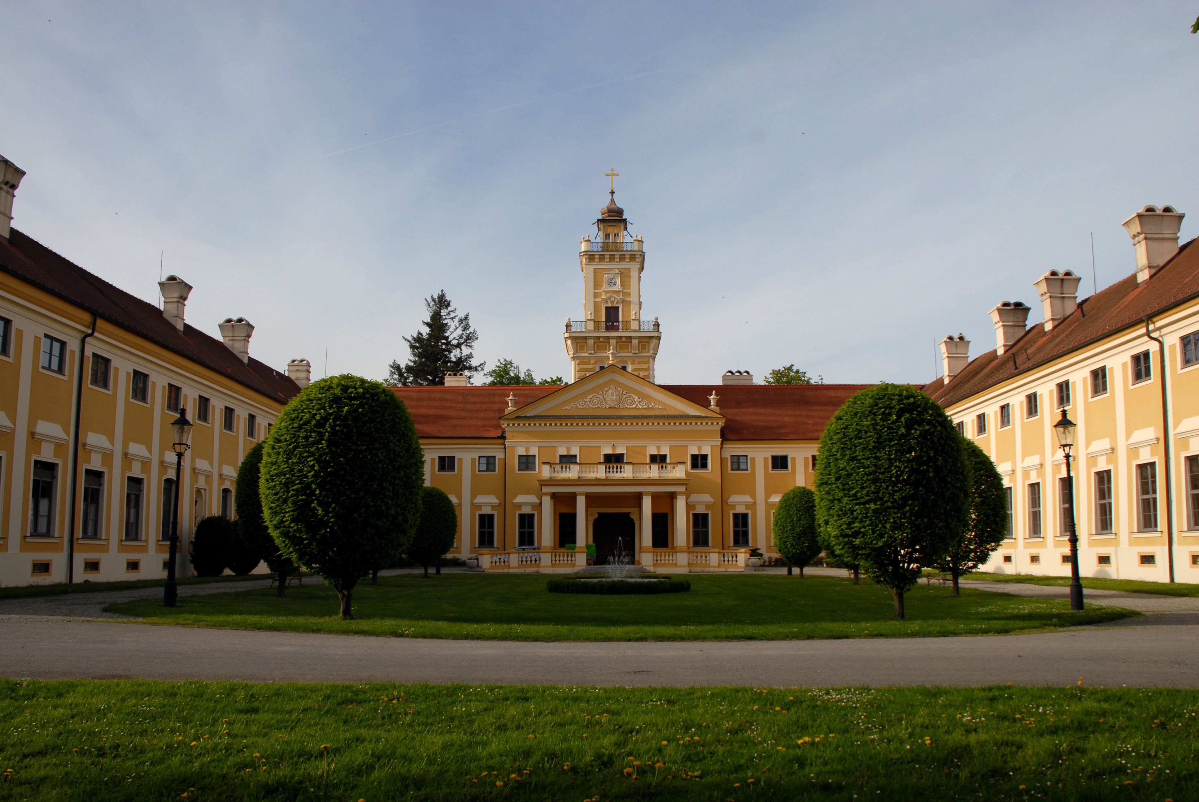 Zámok Jaidhof so žltou fasádou a vežou, obklopený udržiavanou záhradou.