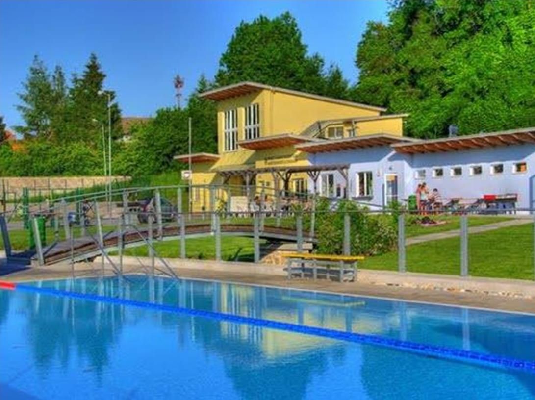 Vonkajší bazén Altlengbach s bazénom a budovou v pozadí.