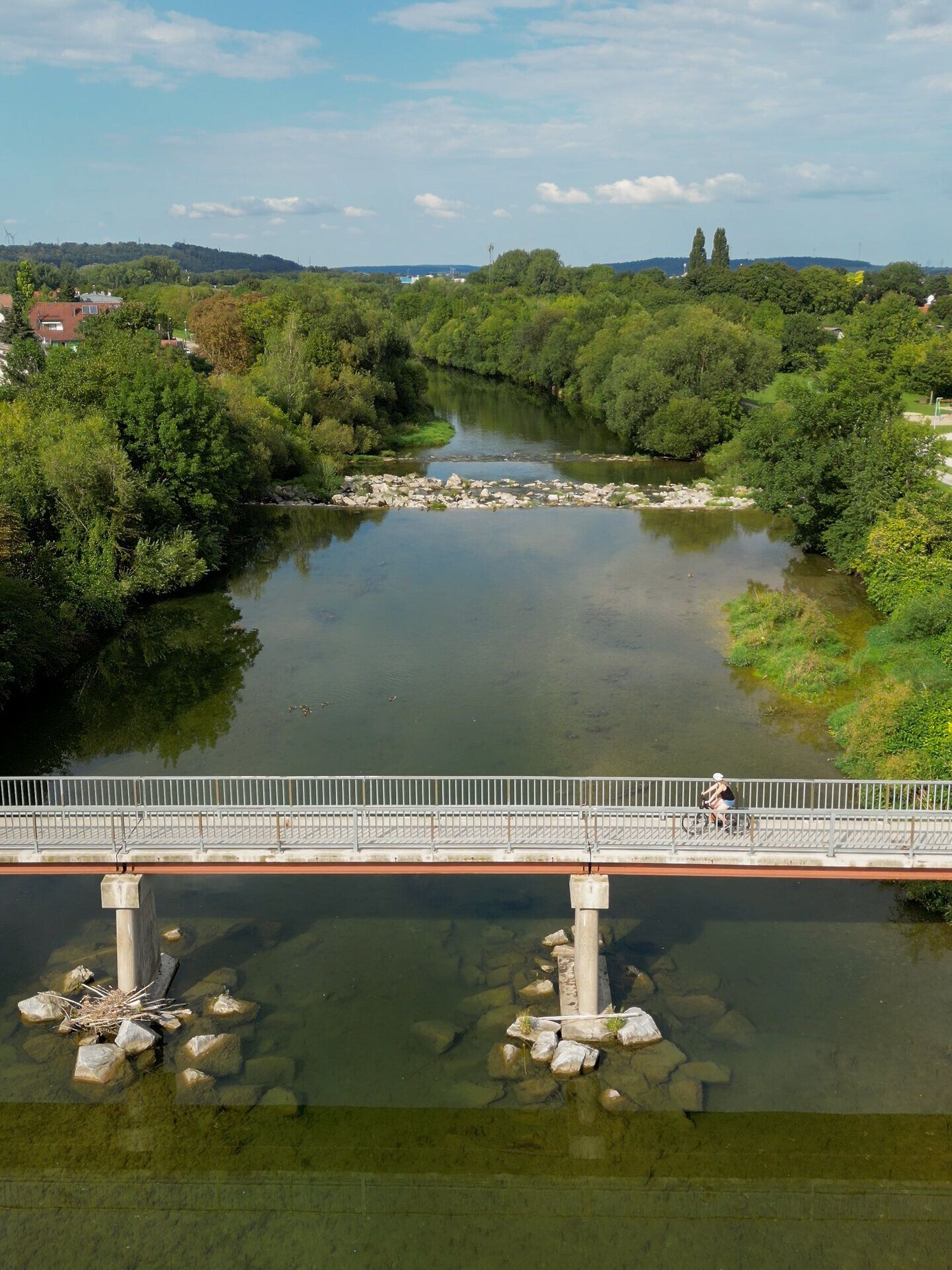 Ein malerischer Radweg schlängelt sich entlang des glitzernden Wassers, umgeben von üppigem Grün und sanften Hügeln. Die friedliche Atmosphäre lädt dazu ein, die Natur in vollen Zügen zu genießen und die Schönheit der Landschaft zu erkunden.