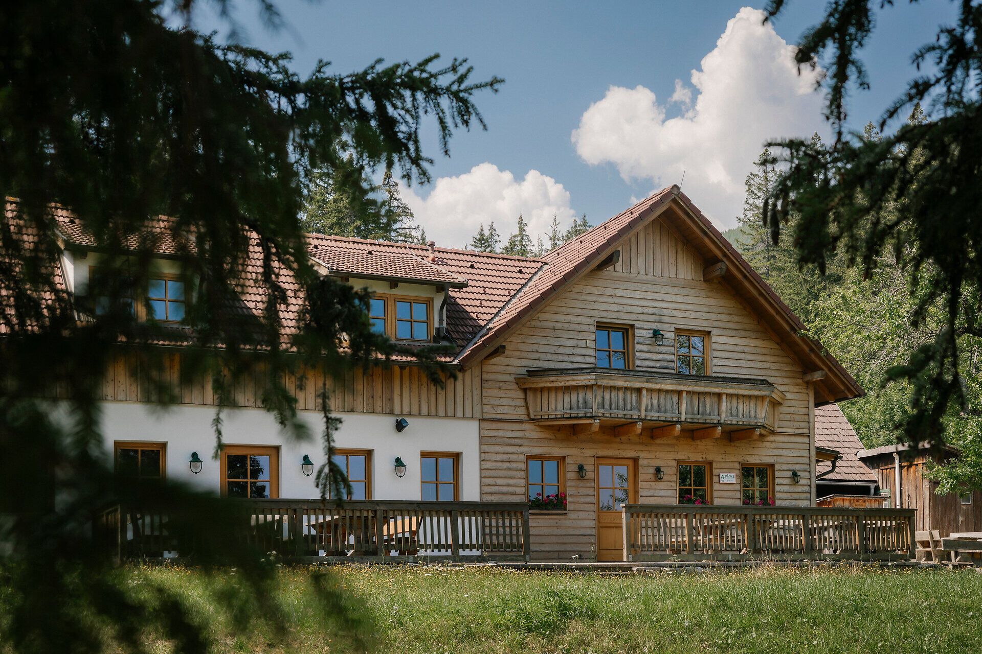 Vonkajší pohľad na chatu Hengsthütte na vrchu Schneeberg s dreveným balkónom a terasou
