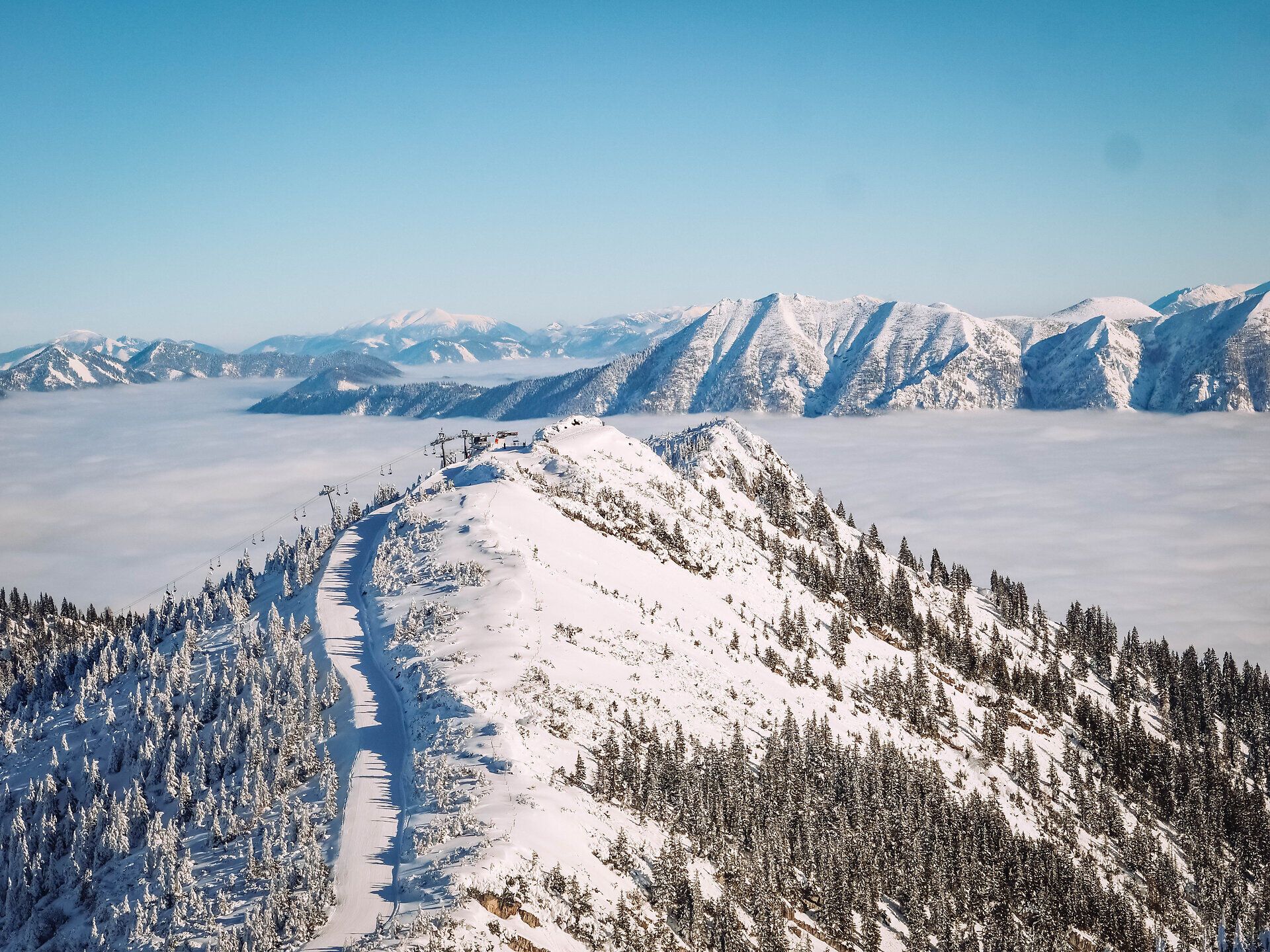 Die schneebedeckten Gipfel erstrahlen im Sonnenlicht und laden Familien zu unvergesslichen Abenteuern ein. Die klare, kalte Luft und die glitzernde Schneedecke schaffen eine magische Winterlandschaft, die zum Spielen und Entspannen einlädt.