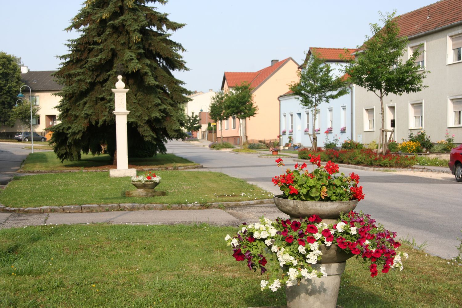 Ulica v Sierndorfe s farebnými kvetmi a domami.