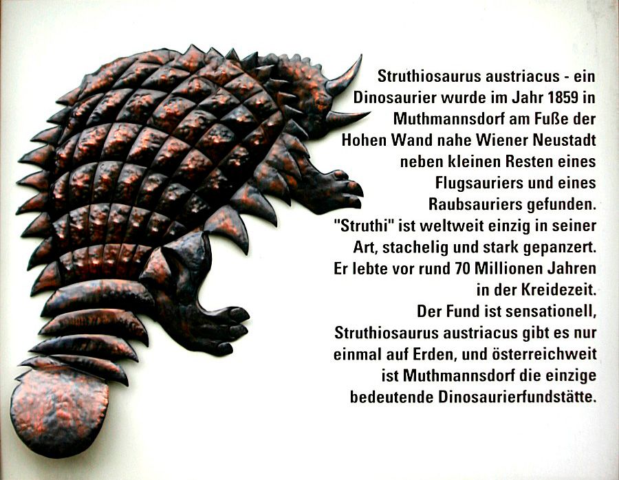 Reliéf obrneného dinosaura s textom o Struthiosaurus austriacus.