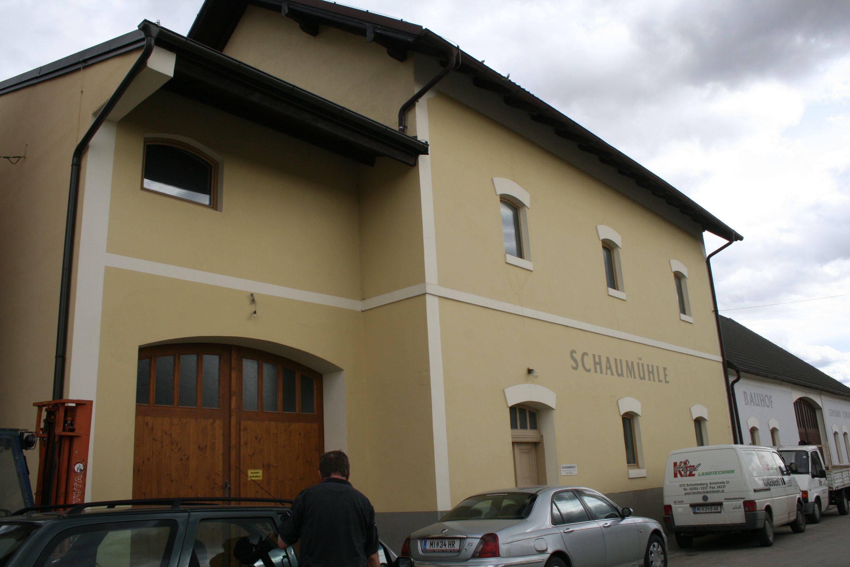 Pohľad zvonku na žltú budovu s označením "Schaumühle".