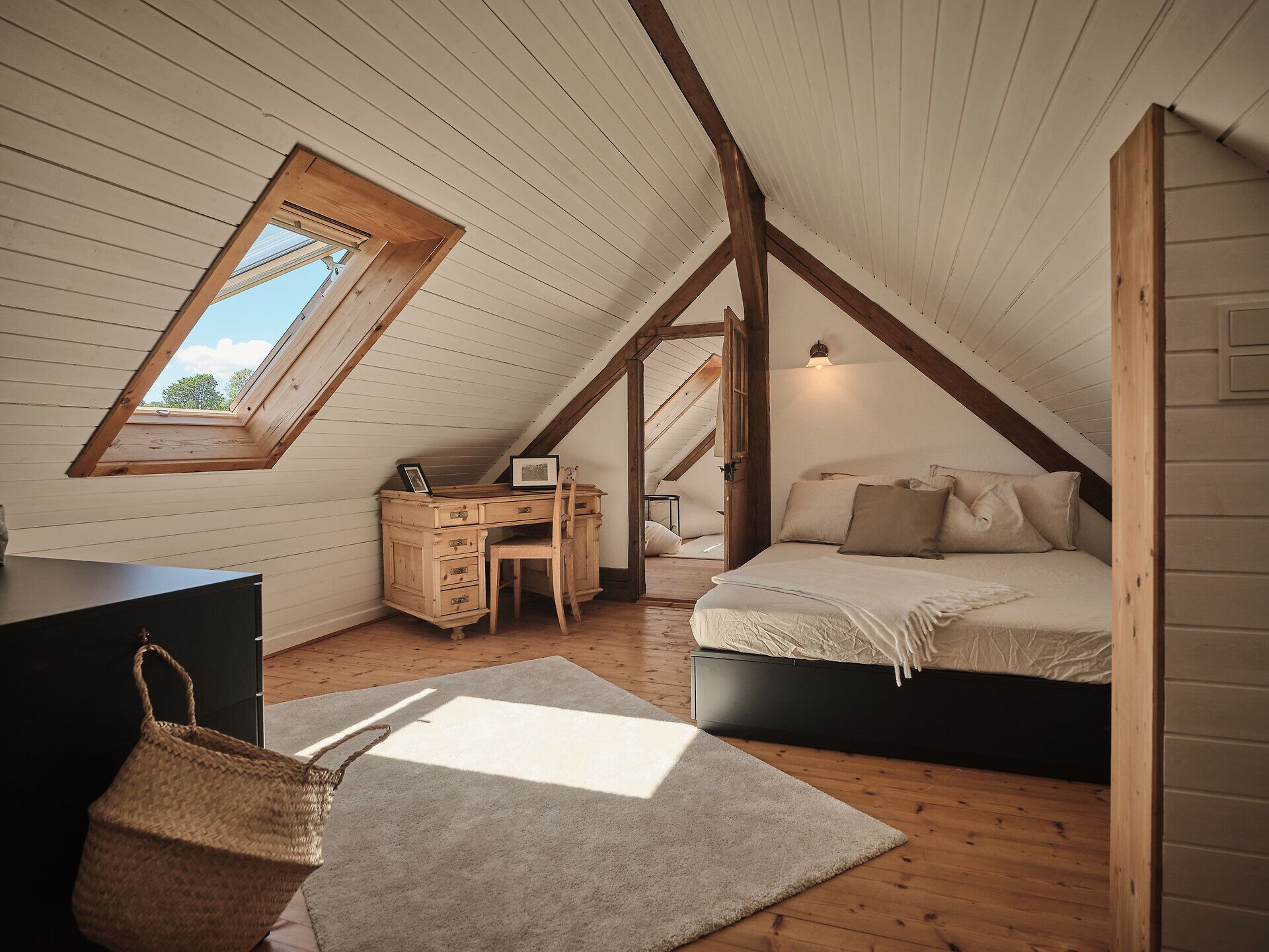 Rustikálny kamenný dom s drevenými dverami, lavičkou a kvetmi v popredí.