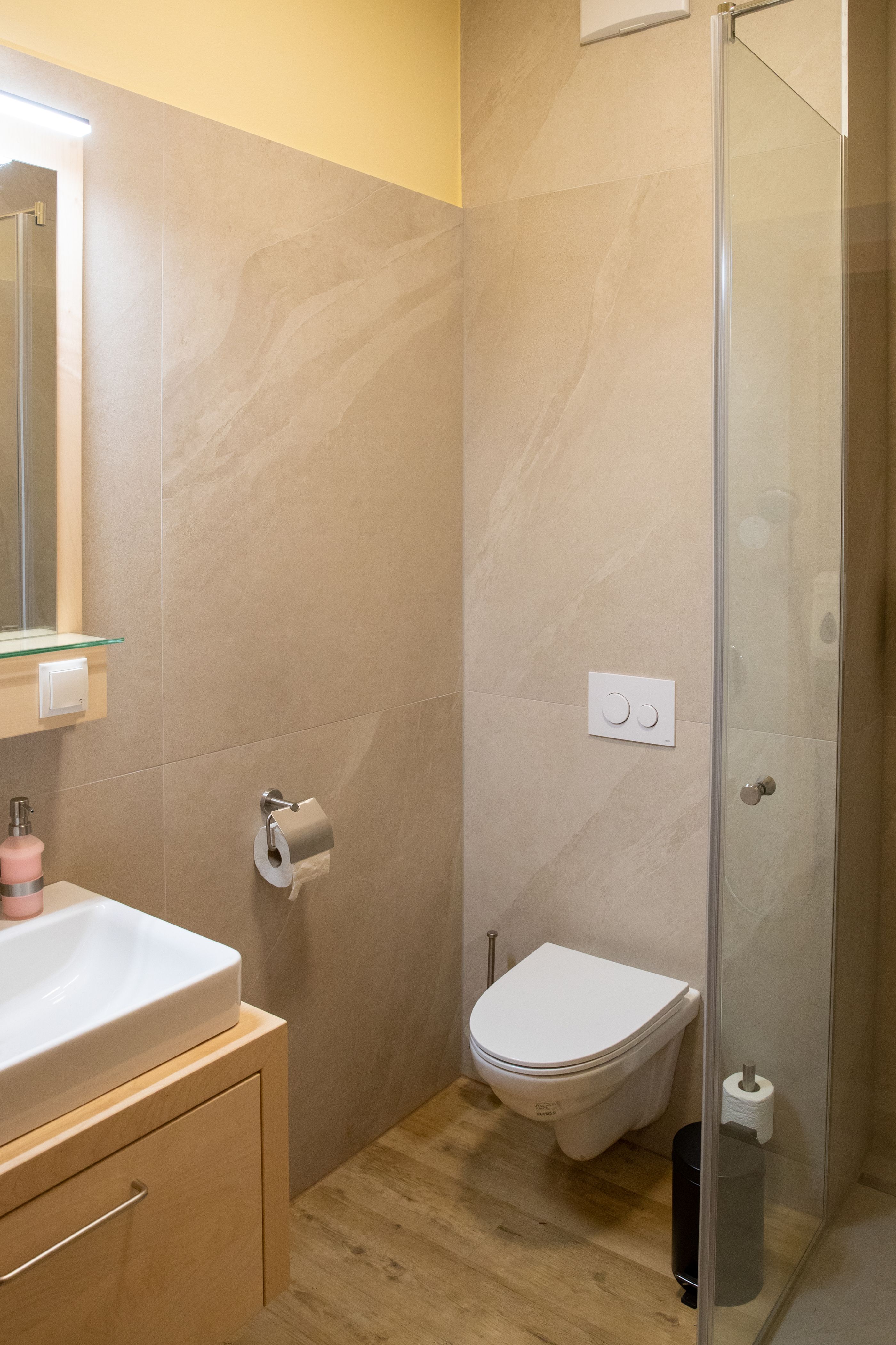 Moderná kúpeľňa s umývadlom, toaletou a sprchovacím kútom.