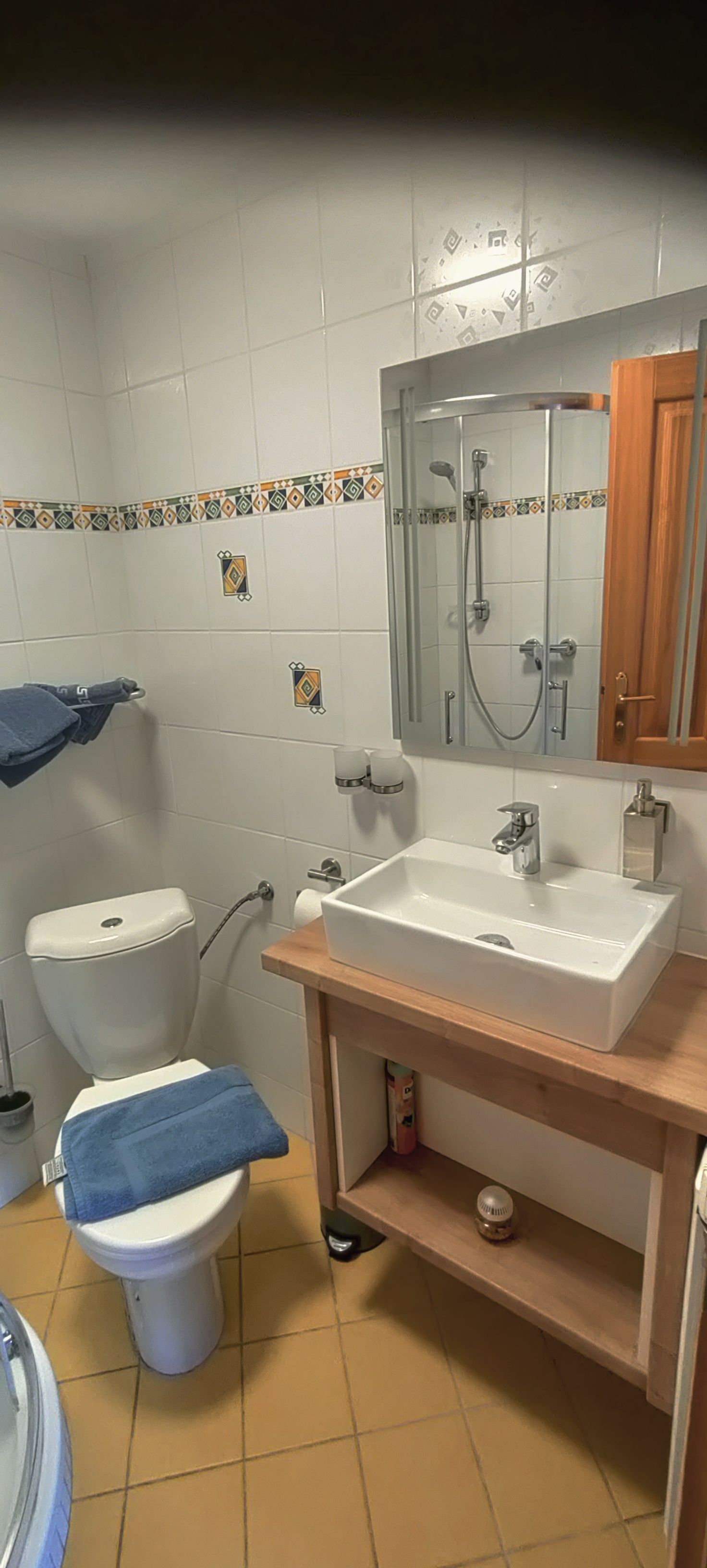 Malá kúpeľňa s WC, umývadlom a zrkadlom.