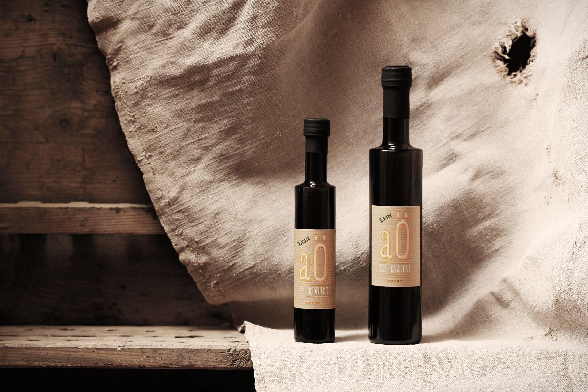 Dve fľaše ľanového oleja na rustikálnom pozadí.