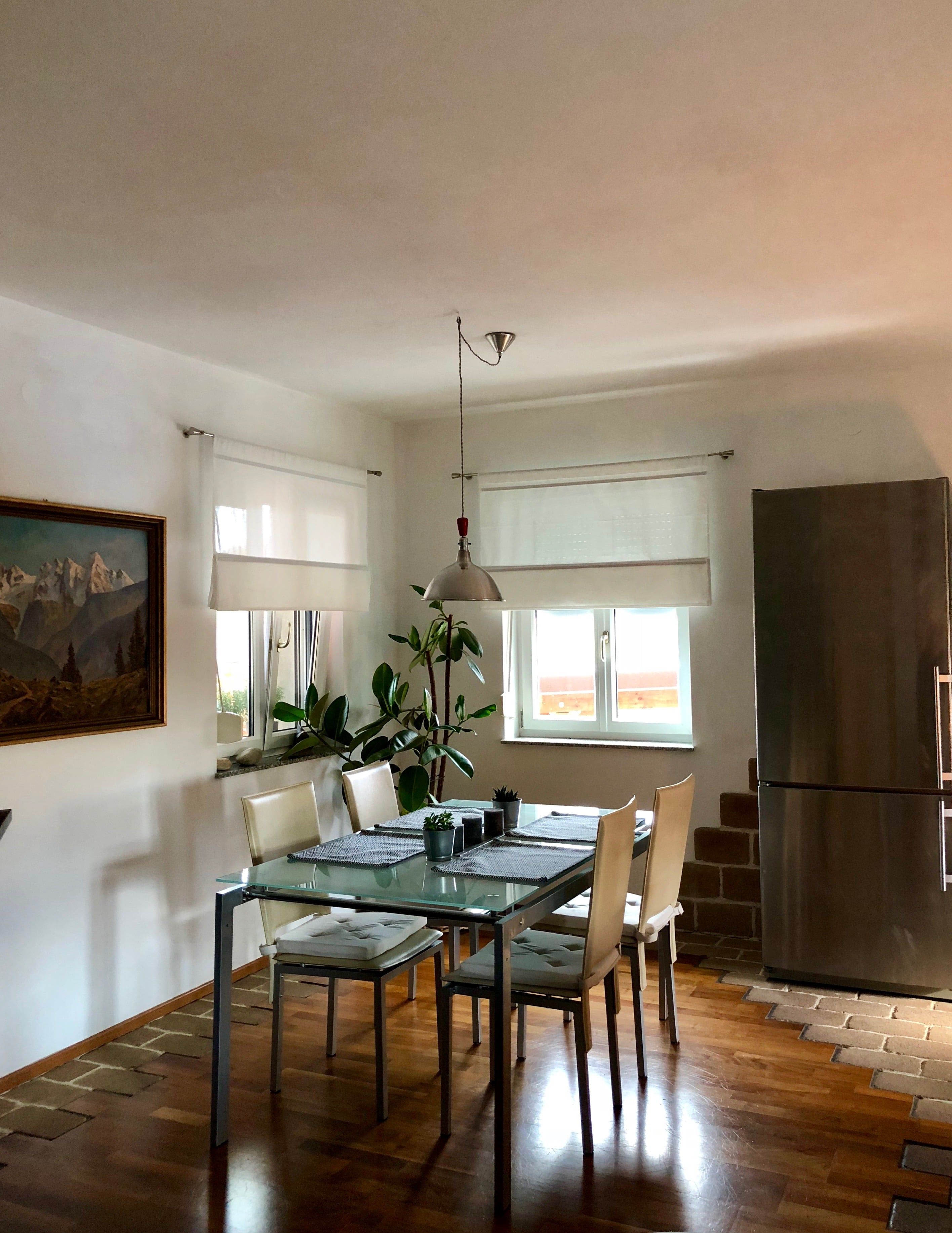 Otvorený obývací a jedálenský priestor so stolom, stoličkami a prirodzeným svetlom.