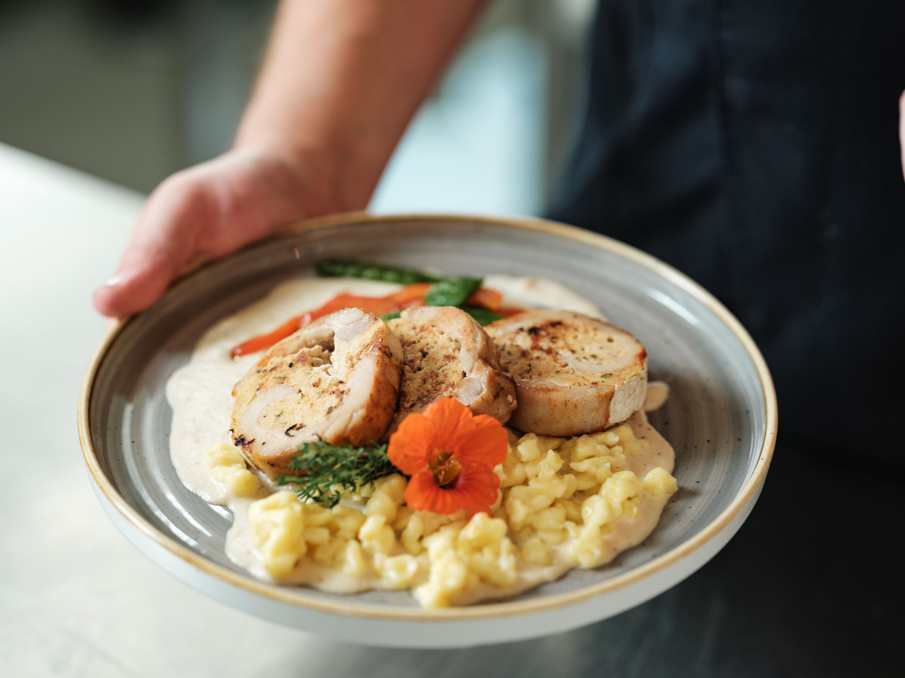 Tanier s plneným mäsom, špecľami, zeleninou a kvetom ako ozdobou.