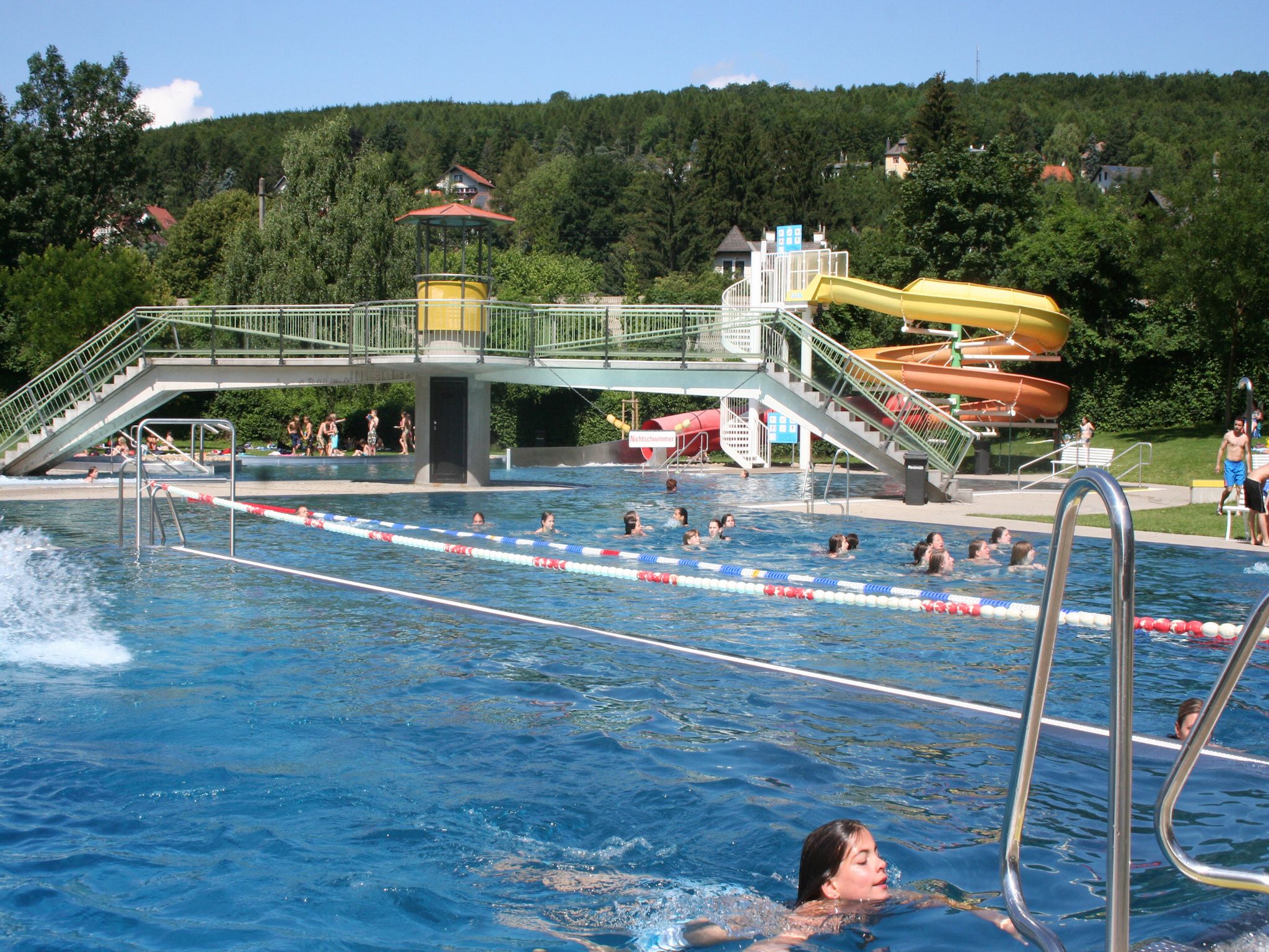 Vonkajší bazén s plavákom, šmykľavkou a mostíkom v kúpeľoch Wienerwaldbad Purkersdorf.