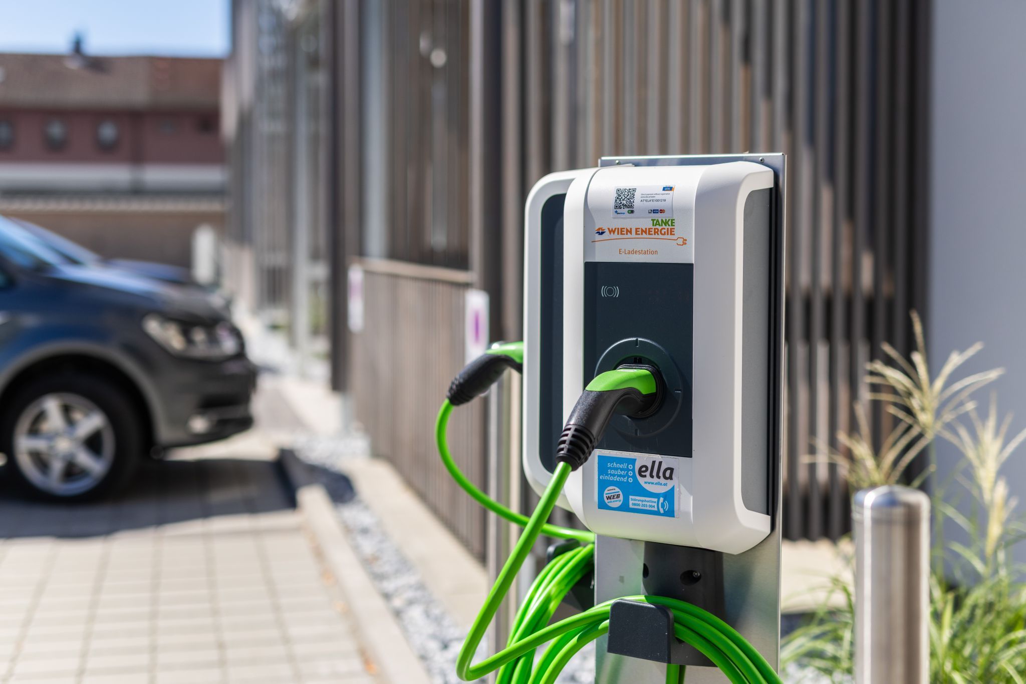 Vonkajšia elektrická nabíjacia stanica spoločnosti Wien Energie so zeleným káblom.