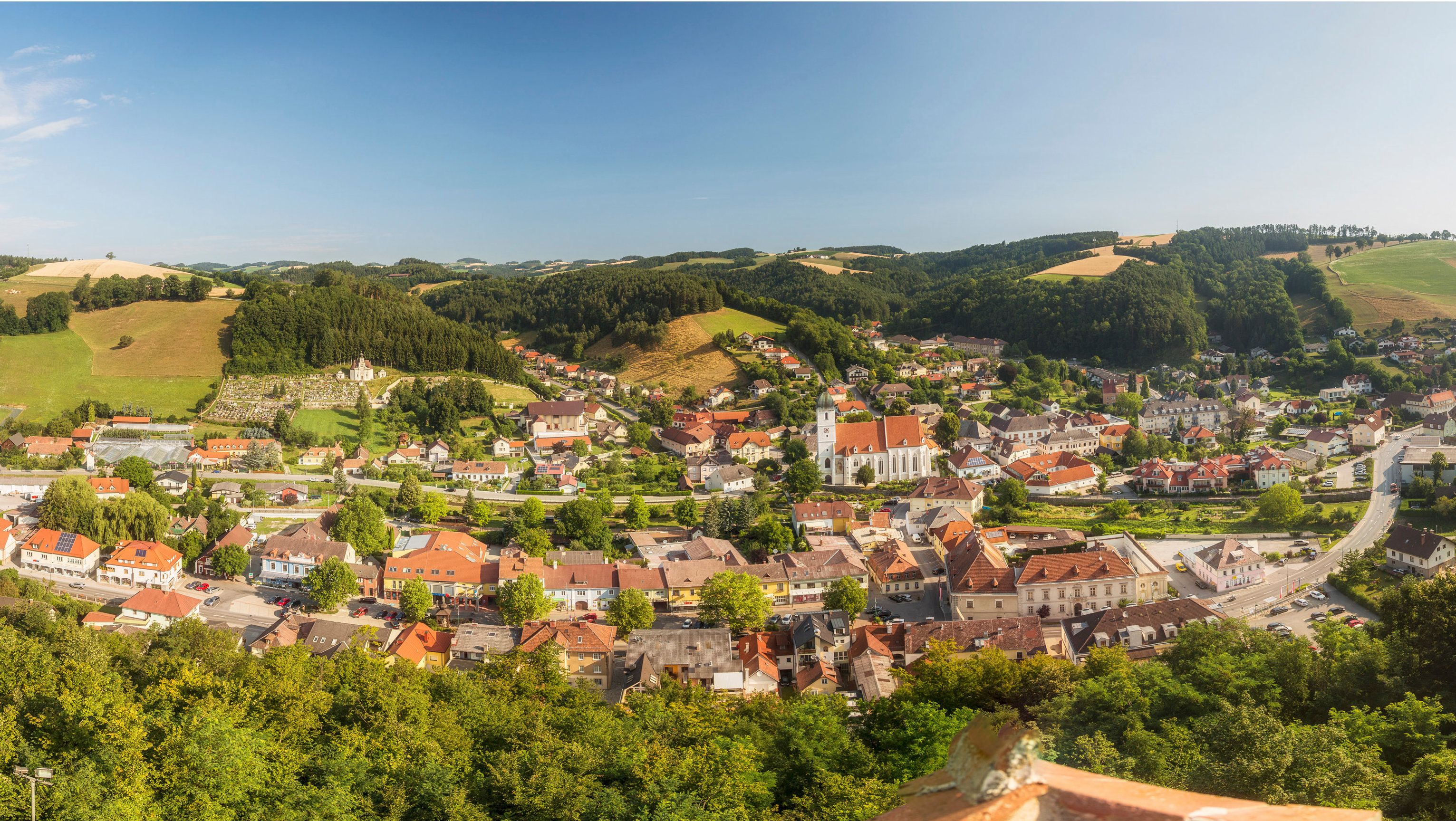 Panoramatický pohľad na Kirchschlag v Buckeligé Welt s kostolom a okolitými kopcami.
