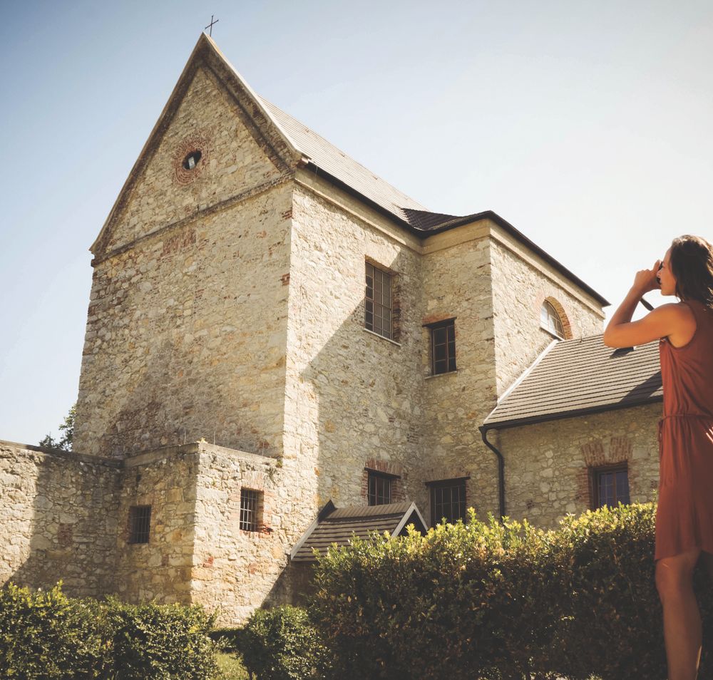 Eine Frau fotografiert das Kloster St. Anna in der Mannersdorfer Wüste. 
