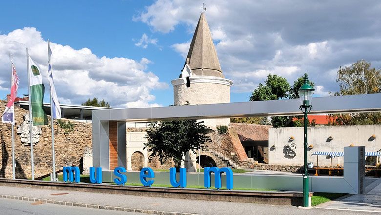 Vchod do Hornského múzea s moderným nápisom a historickou vežou v pozadí.