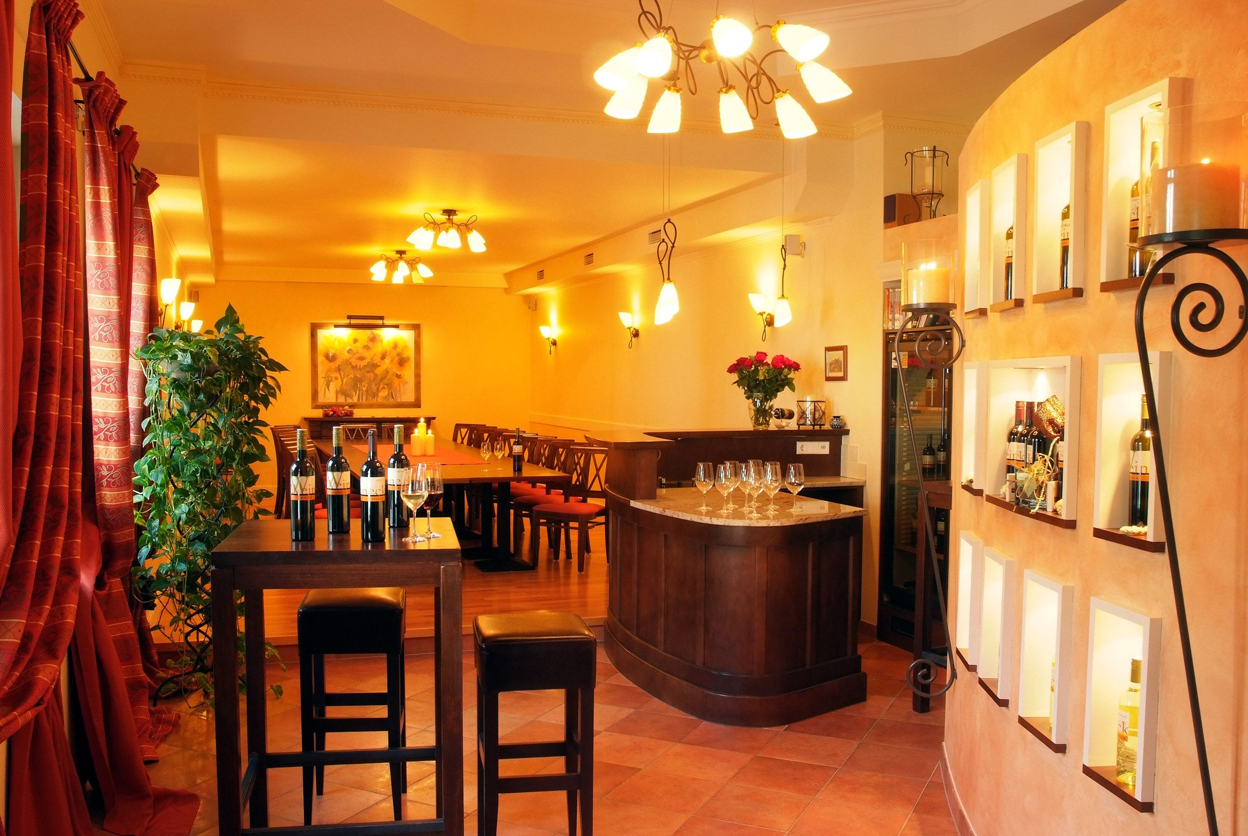 Elegantná degustačná miestnosť s fľašami vína, pohármi a štýlovým osvetlením.