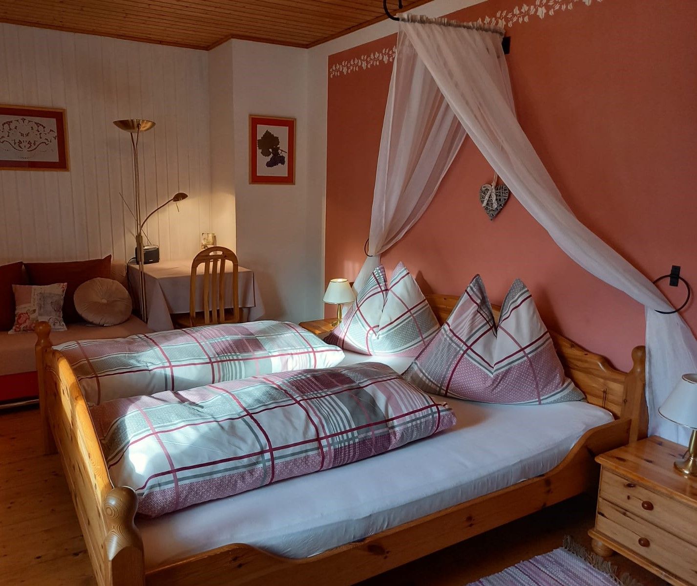 Útulná izba pre hostí s manželskou posteľou, nočnými lampami a písacím stolom.