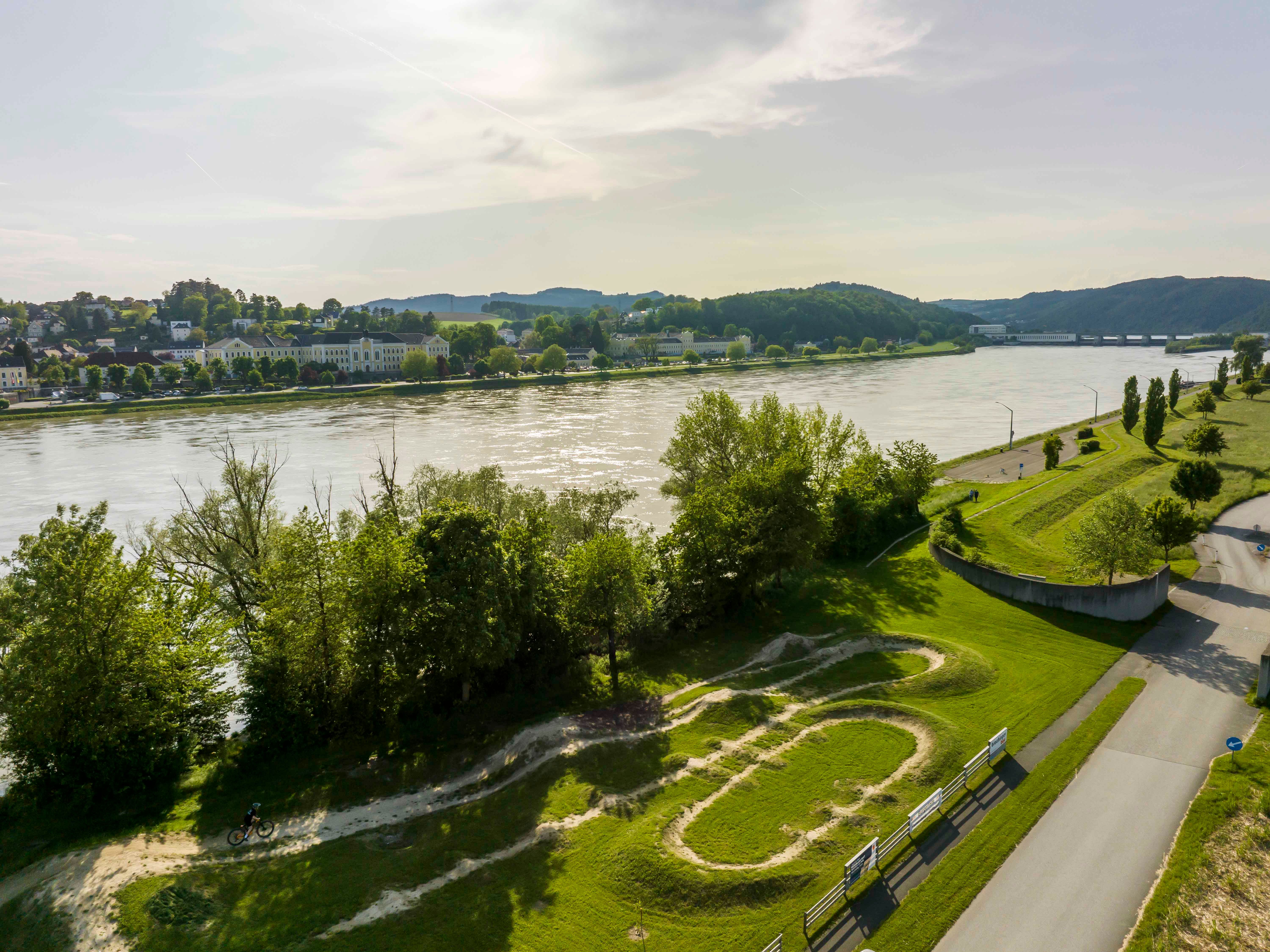 Letecký pohľad na cyklistickú arénu Persenbeug-Gottsdorf s riekou a okolitou krajinou.