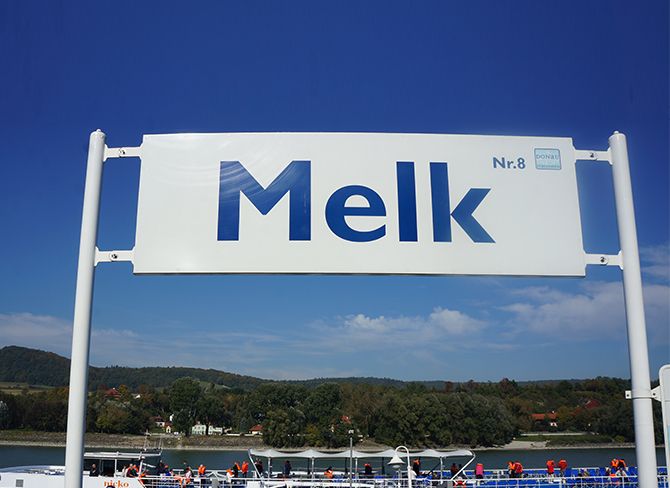 Značka s nápisom "Melk Nr. 8" na modrej oblohe.