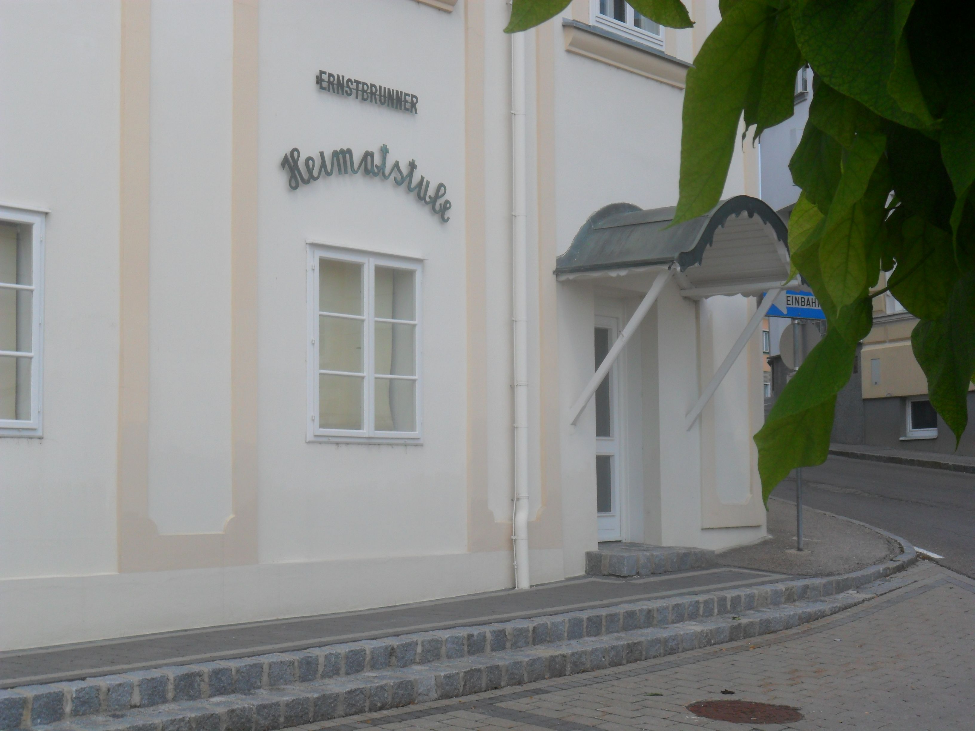 Vchod do miestneho historického salónu Ernstbrunn s prístreškom a dopravnou značkou.