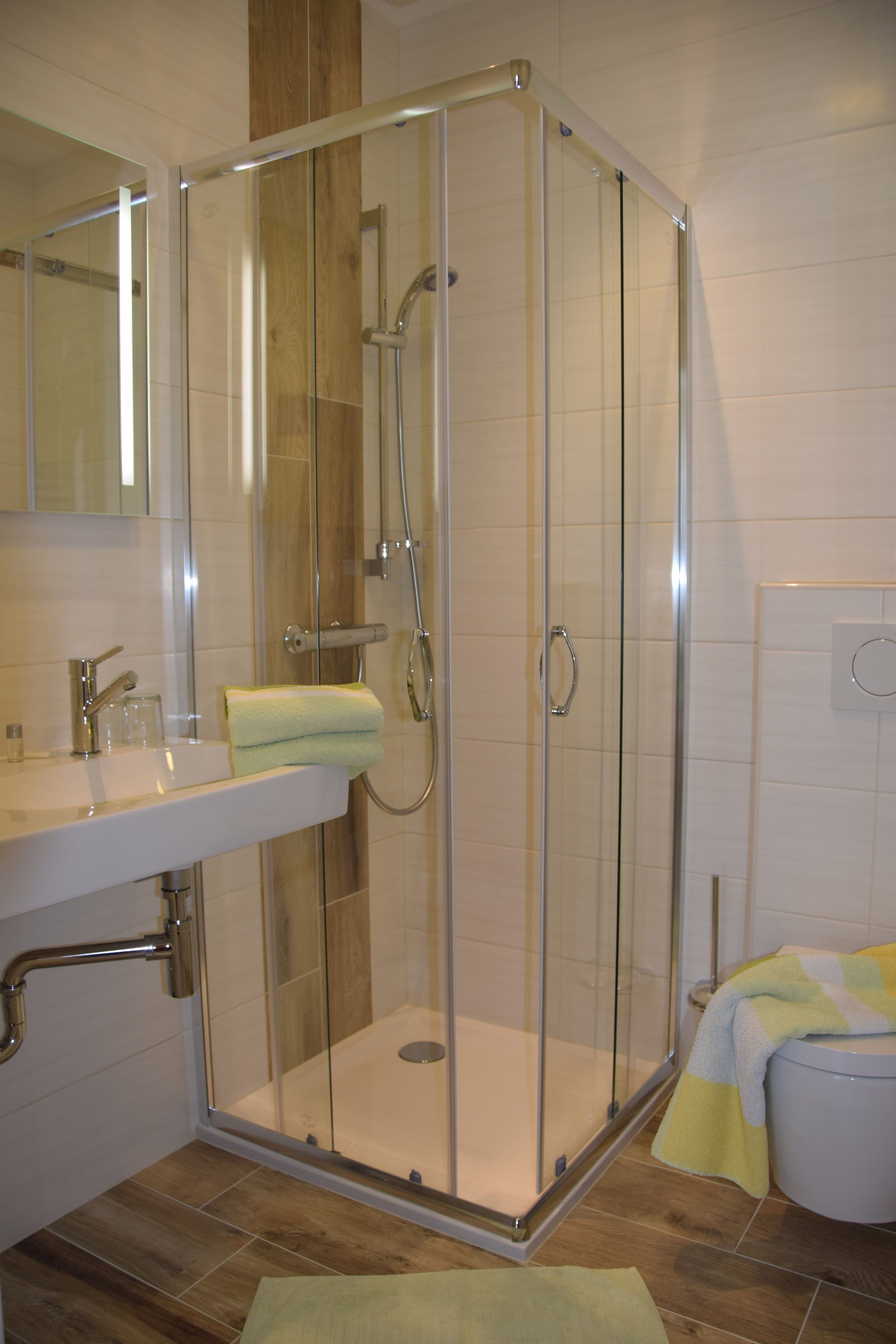 Moderná kúpeľňa so sprchovacím kútom, umývadlom a WC.