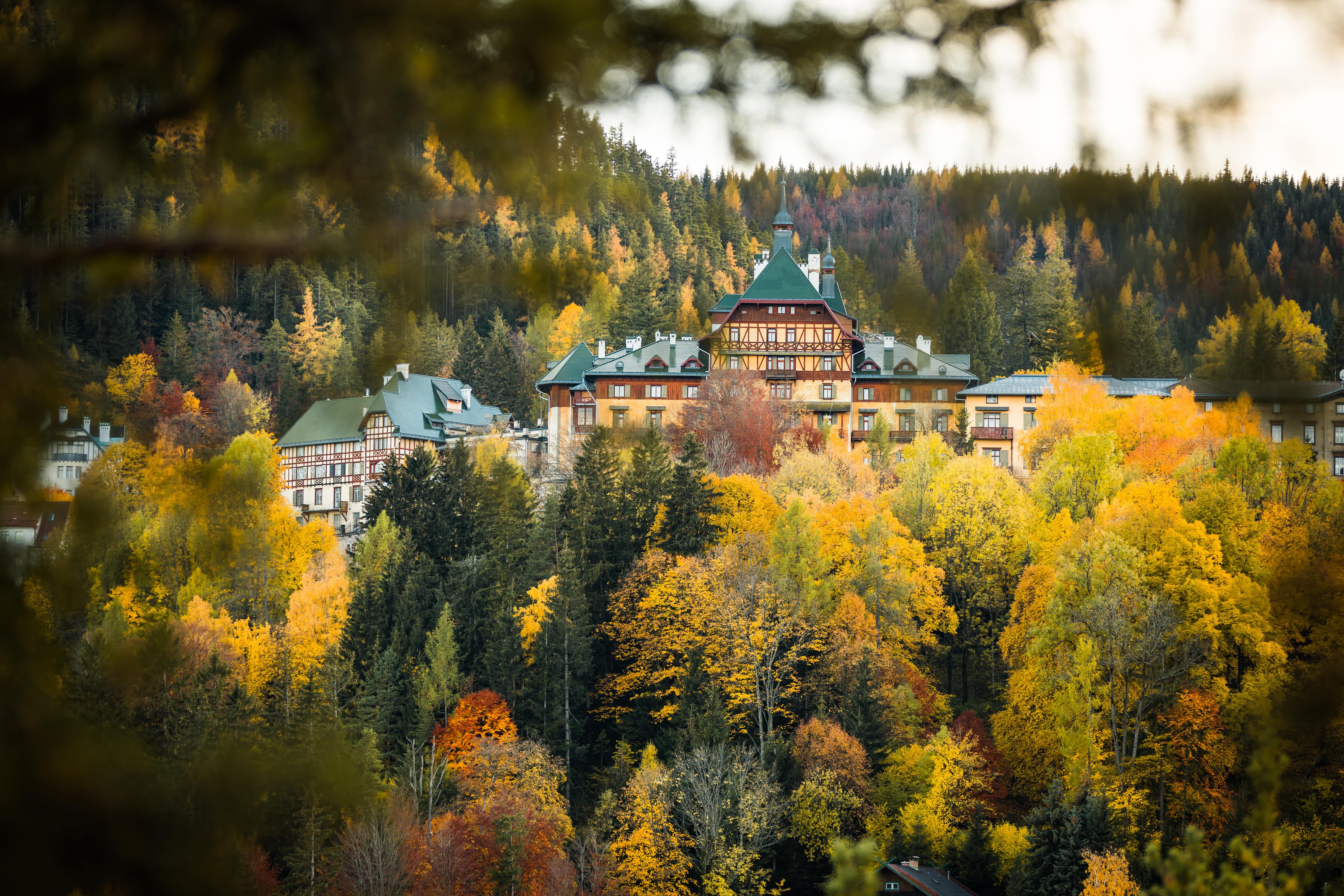 Südbahnhotel Semmering na jeseň, obklopený farebným listnatým lesom.