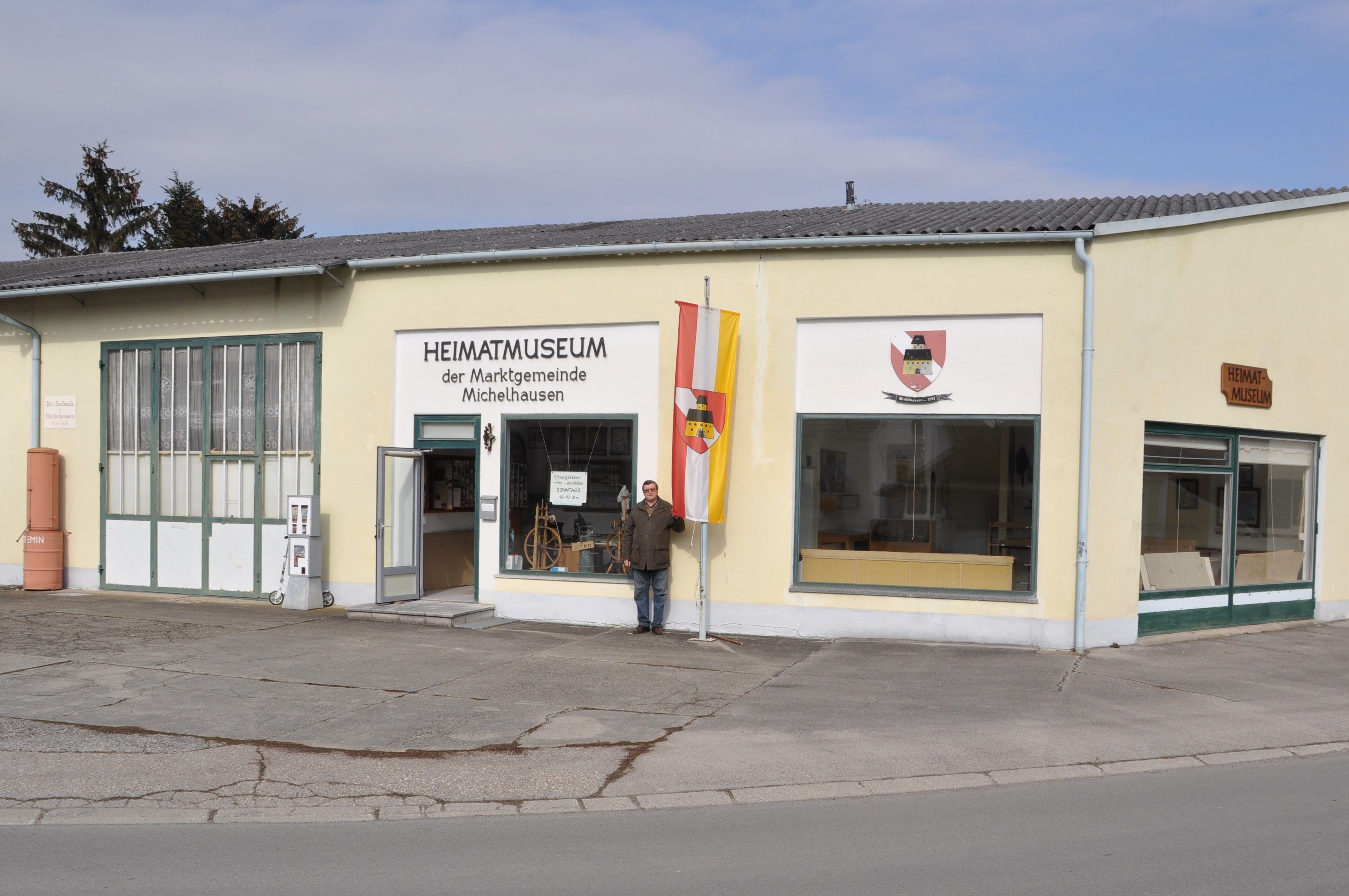 Vonkajší pohľad na Múzeum miestnej histórie Michelhausen so žltou budovou a vlajkou.