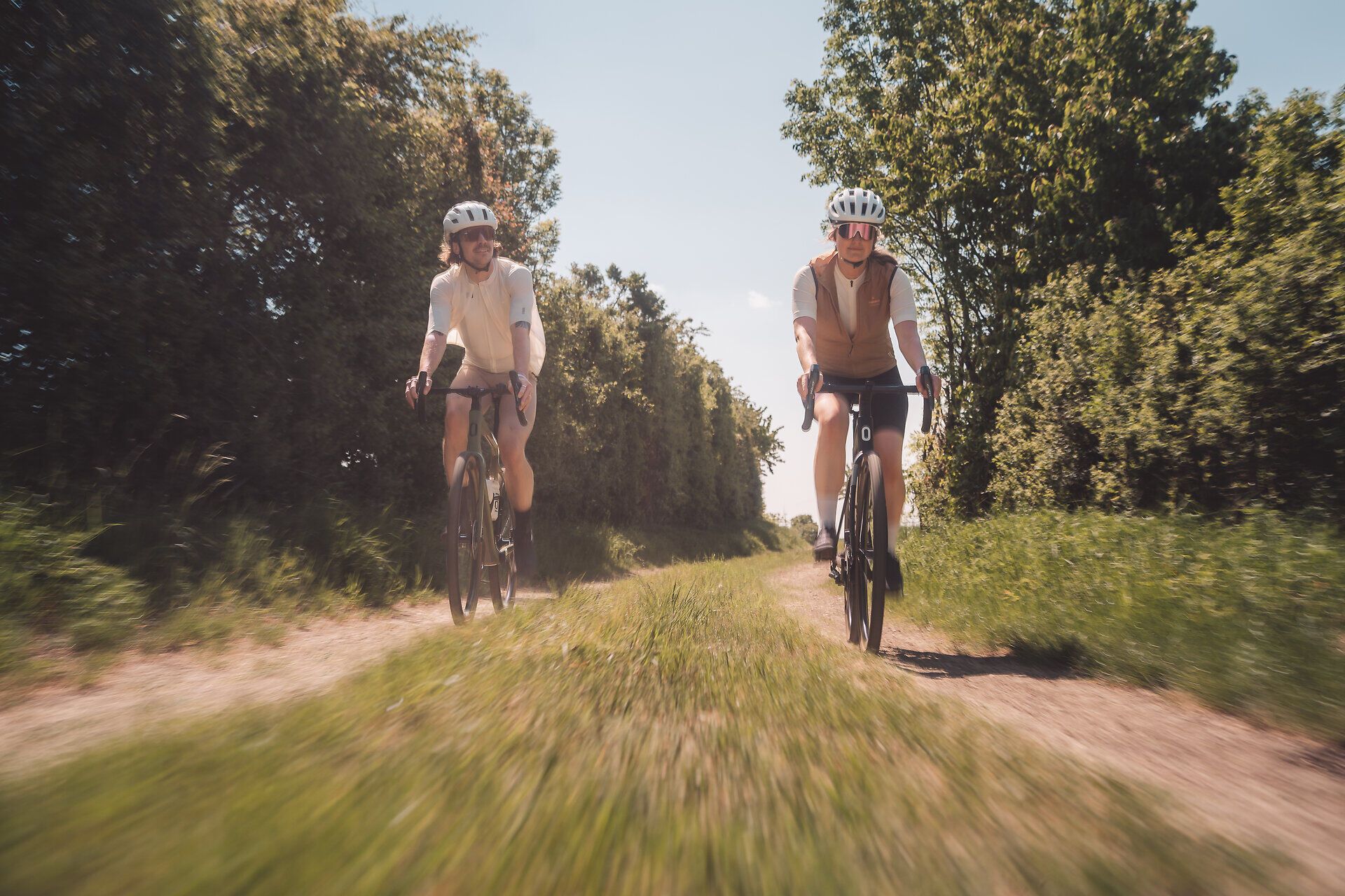 Zwei Radfahrer sind auf Gravelbikes in der Weinviertler Landschaft unterwegs.