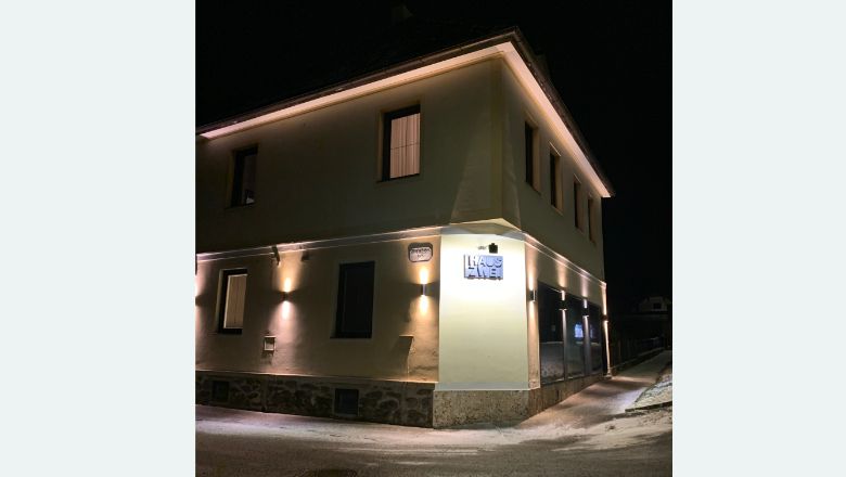 Budova osvetlená v noci s nápisom "Haus Zwei".