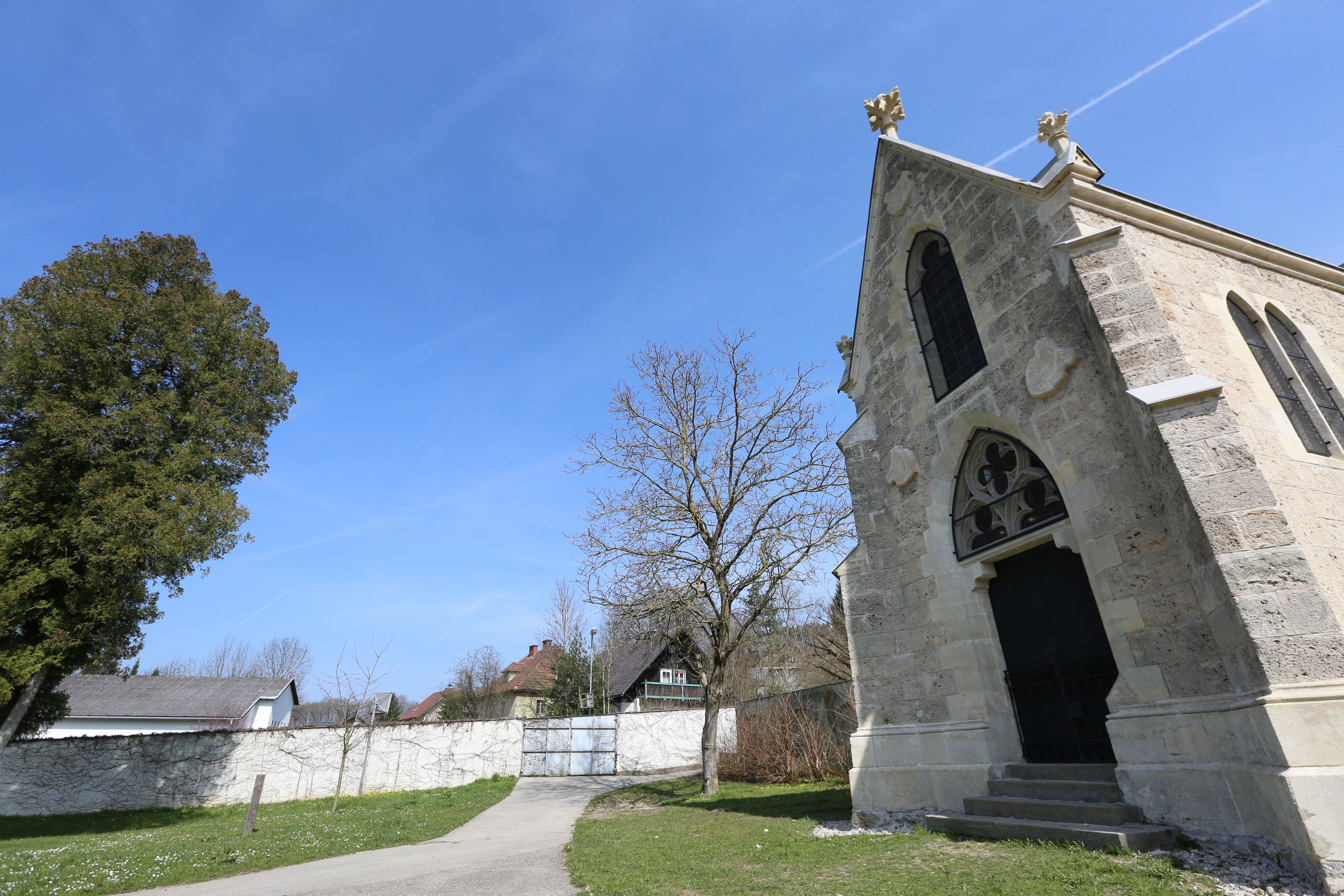 Töppermausoleum s modrou oblohou a stromami v pozadí.