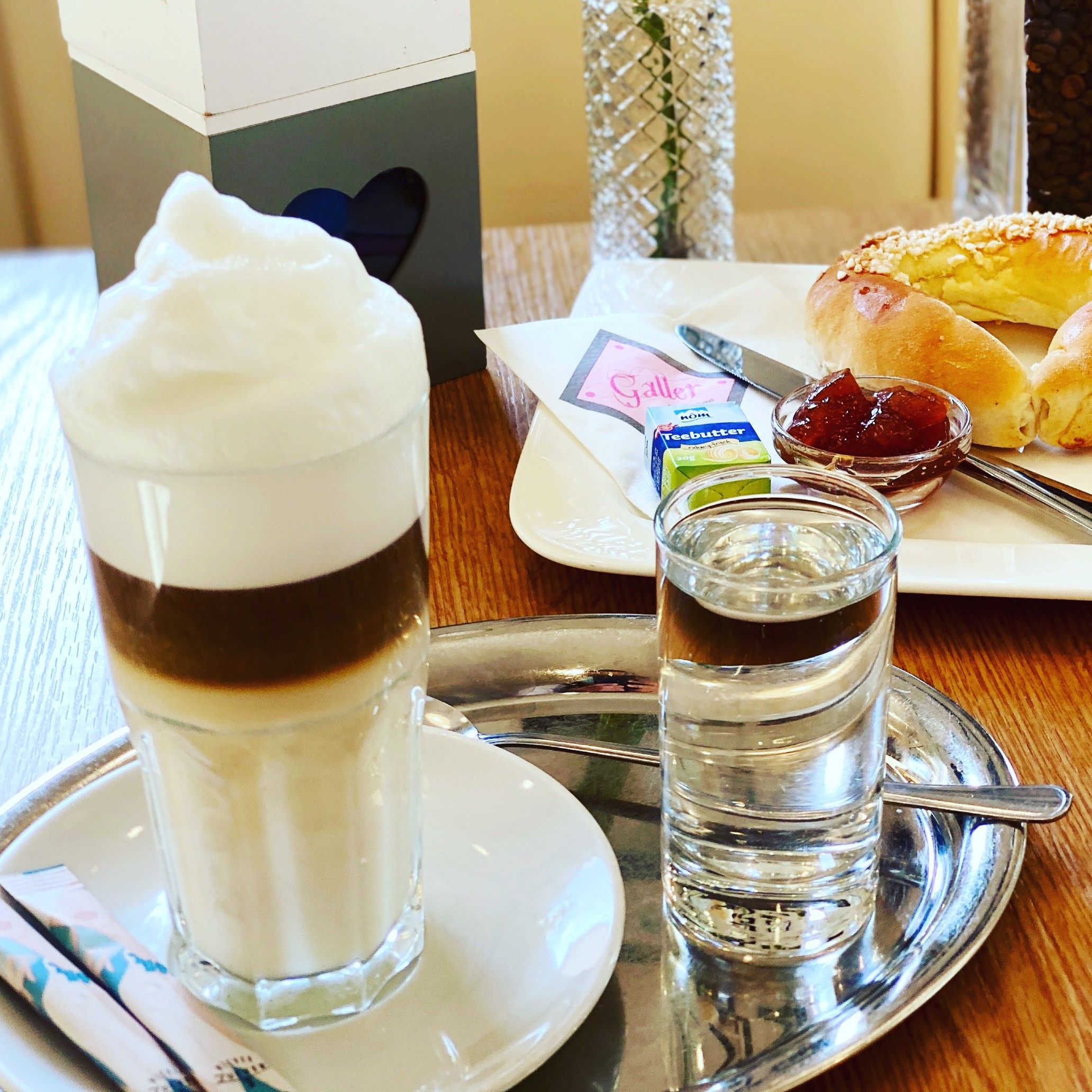 Raňajkový stôl s latte macchiato a brioškovými croissantmi s džemom 