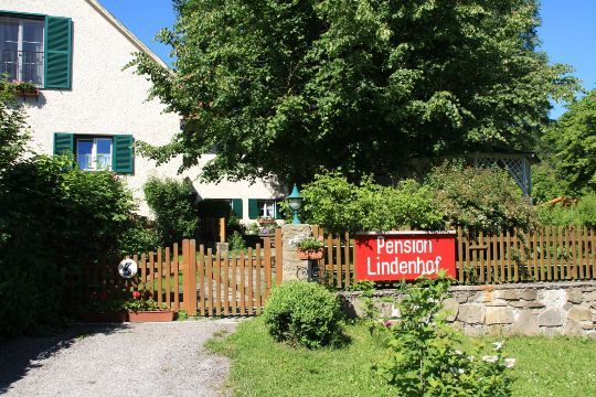 Dom so záhradou a nápisom "Pension Lindenhof" na drevenom plote.