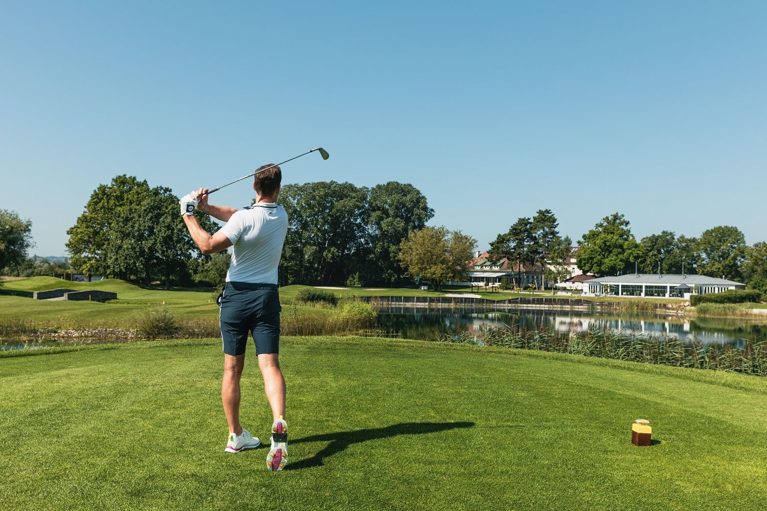 Golfista s golfovou palicou v ruke hrá golf.