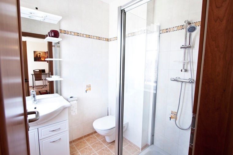 Moderná kúpeľňa so sprchovacím kútom, umývadlom a WC.