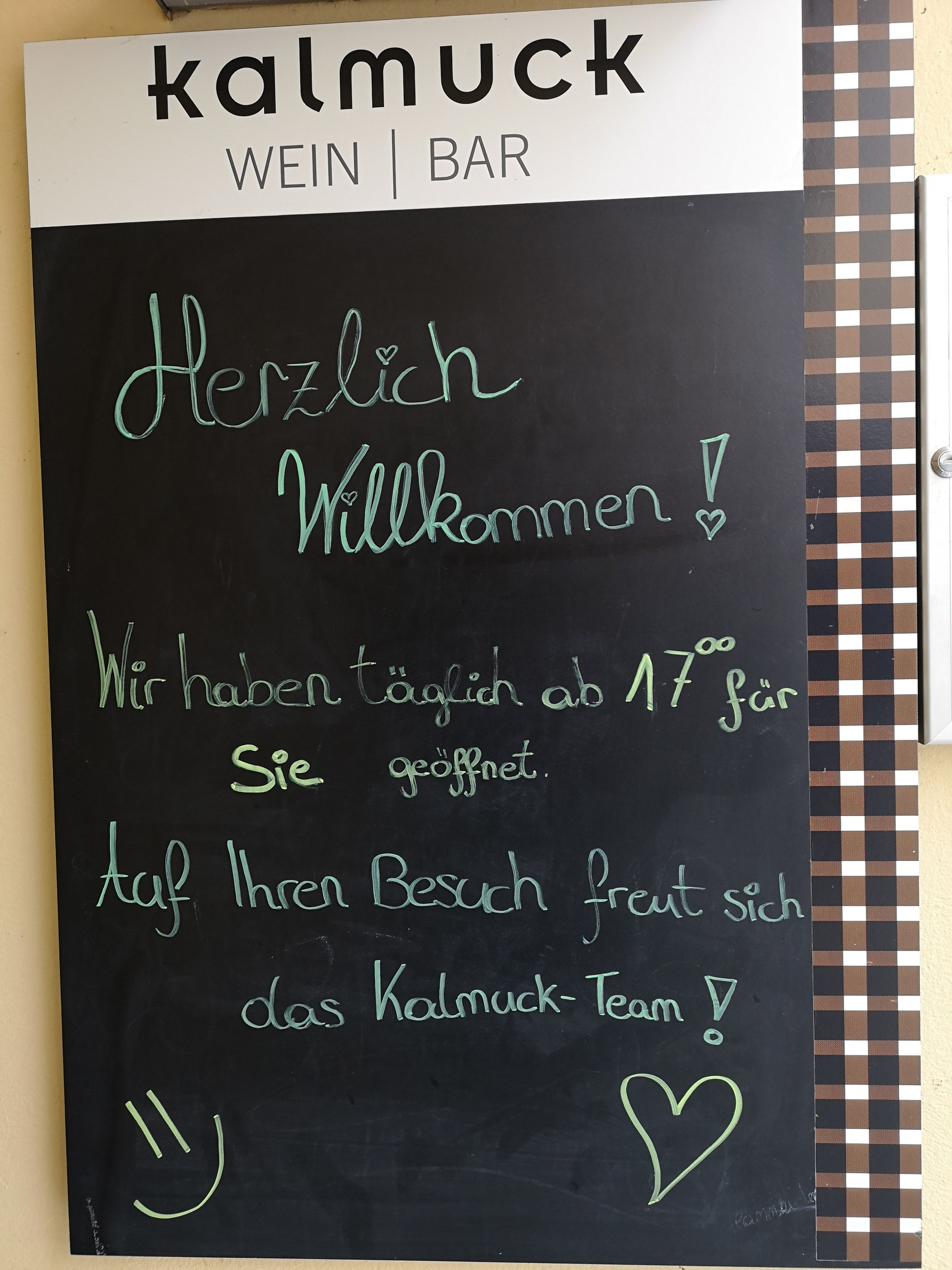 Tabuľa s uvítacím textom pred vinárňou Kalmuck.