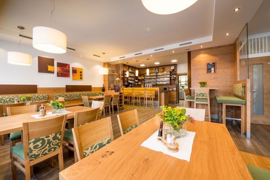 Pohľad do interiéru útulného hostinca s dreveným nábytkom a barom.