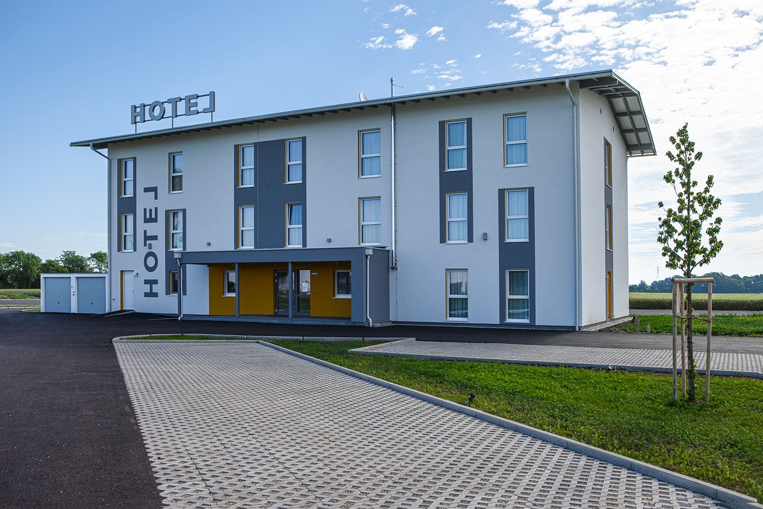 Vonkajší pohľad na hotel s parkoviskom.