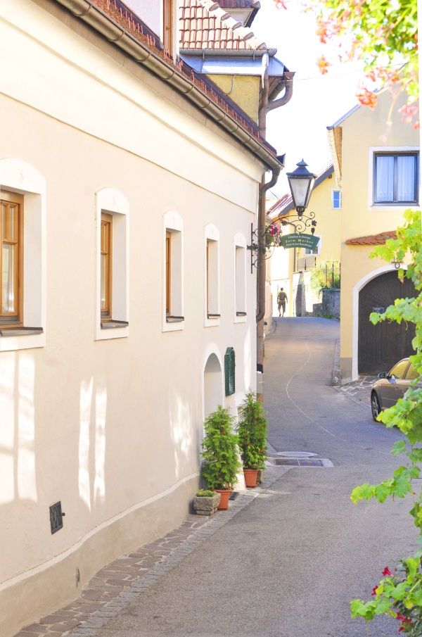 Úzka ulička vo Wachau so žltými domami a lampášom.